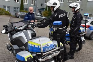 Dwaj policjanci w czarnych kombinezonach z napisem POLICJA stoją przy nowych motocyklach. Prezentują je Komendantowi Powiatowemu policji w Oleśnie inspektorowi Tomaszowi Kubickiemu.