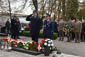 Komendant Powiatowy Policji w Oleśnie i Komendant Powiatowy Państwowej Straży Pożarnej oddają honory salutując pod Pomnikiem Lotników Polskich.