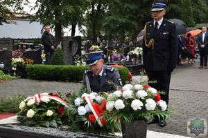 Inspektor Tomasz Kubicki składa wiązankę biało-czerwonych kwiatów przed pomnikiem Lotników Polskich